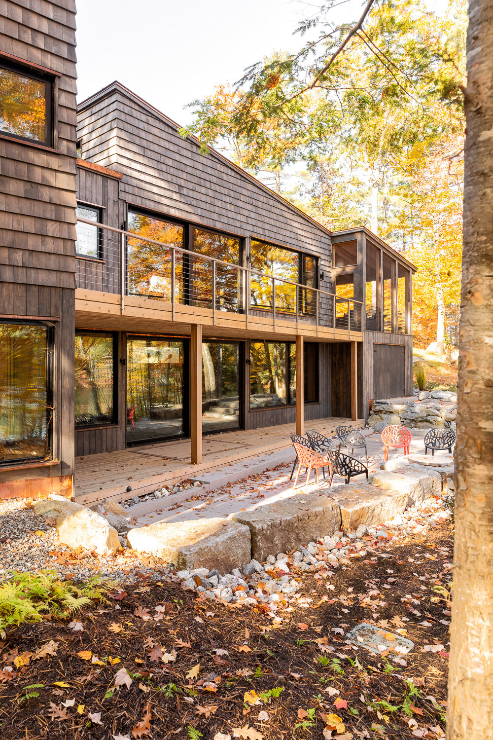  Porches run the length of the great rooms. At the far end of the house, a screened porch sits over a shed for lake gear. The shed was incorporated into the house because permitting allowed only one structure on the property. 