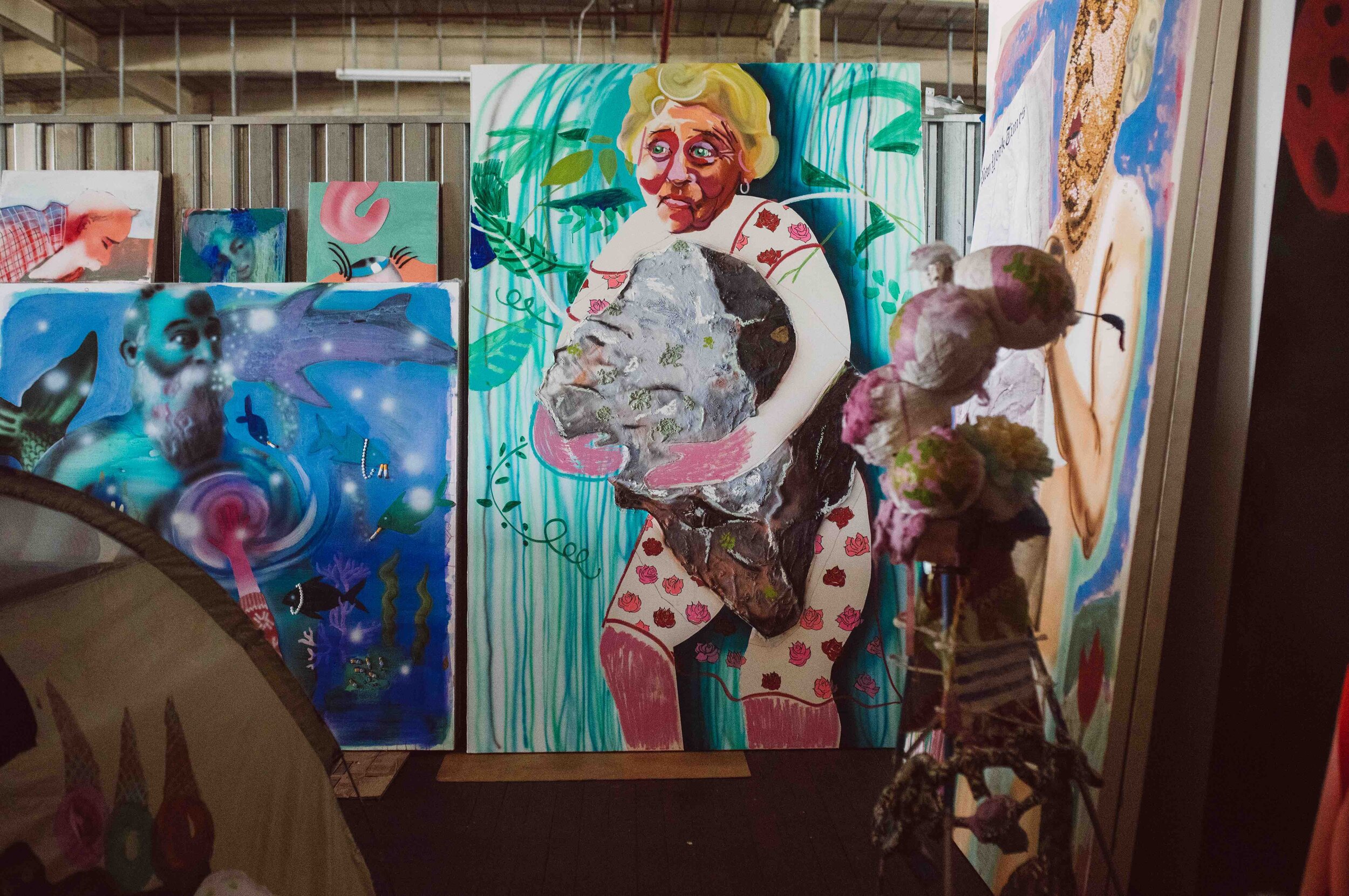  The exuberant colors in Emilie’s paintings contrast starkly with the monochromatic gray and silver tones in John’s nail sculpture. 