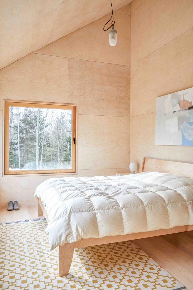 Artwork by Jenny Prinn and a patterned rug from IKEA add color and texture to the main bedroom’s restful simplicity.