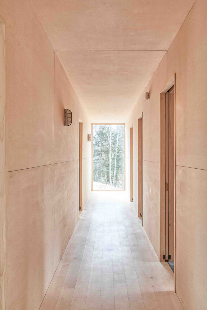  Pocket doors enhance the seamless appearance of the bedroom wing. A large window at the hallway’s end provides natural light.&nbsp; 