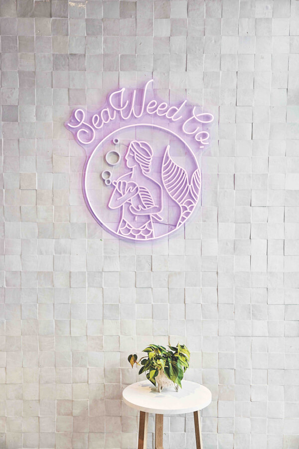 The company’s illuminated mermaid logo casts a mellow lavender glow.